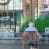 Anciano argentino viendo solo en la vereda el partido de la Selección