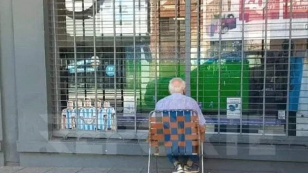 Anciano argentino viendo solo en la vereda el partido de la Selección