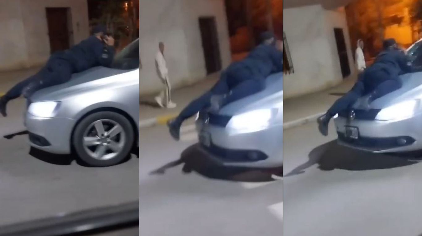 Policía subido a capot de auto en fuga