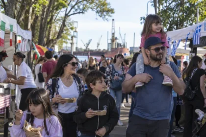 Familias recorriendo puestos gastronómicos en una fiesta del inmigrante