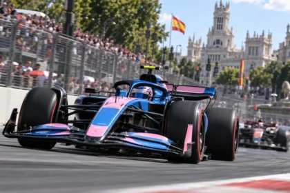 Monoplaza azul y rosa de fórmula 1 en acción durante una carrera urbana en madrid