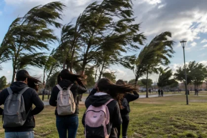 Jóvenes caminando por un parque bonaerense durante una jornada de viento fuerte