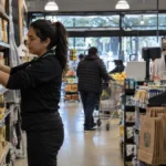 Trabajadora ordenando productos en un supermercado antes de una jornada especial