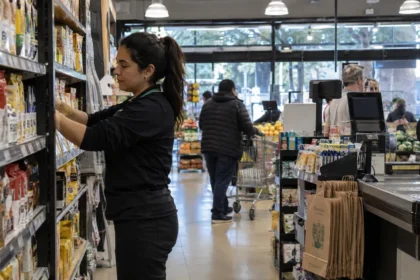 Trabajadora ordenando productos en un supermercado antes de una jornada especial