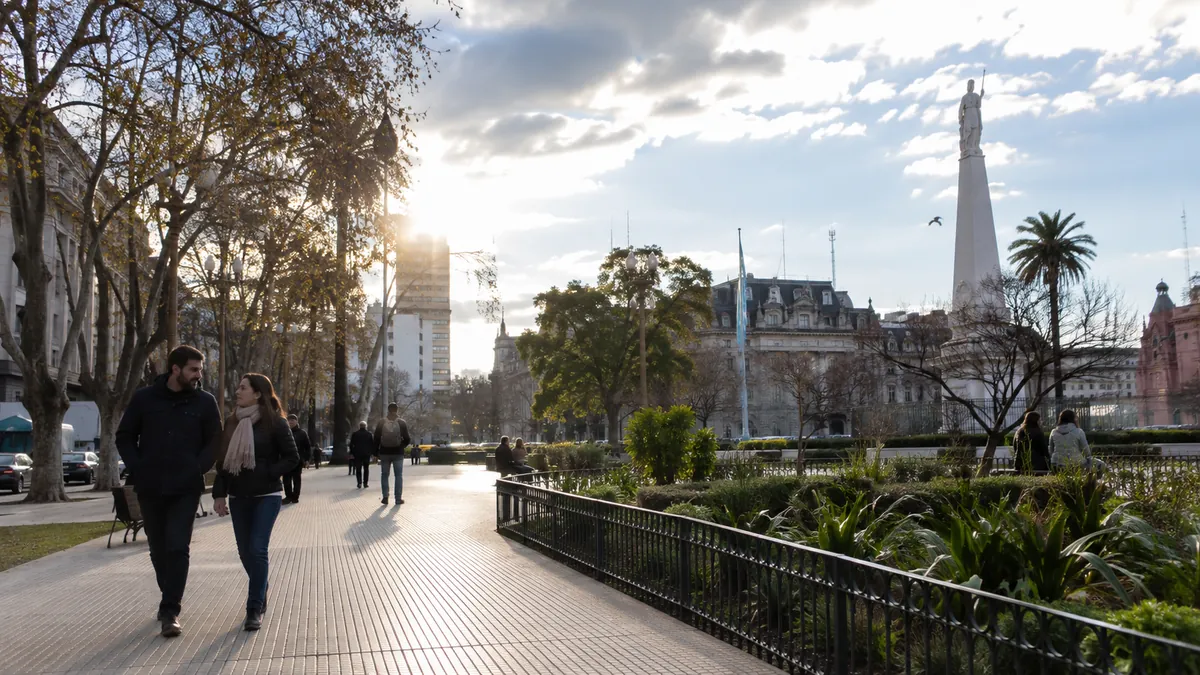 Paseo urbano con sol entre nubes en una jornada fresca de la ciudad
