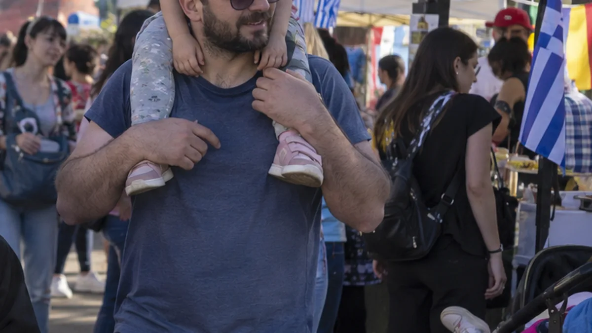 Familias recorriendo puestos gastronómicos durante una fiesta popular
