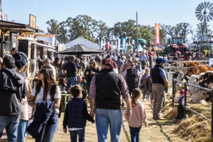 Feria rural con ganado y maquinaria en una exposición agropecuaria