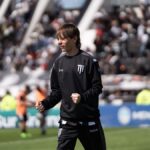 Joven futbolista celebra durante un partido frente a una tribuna llena