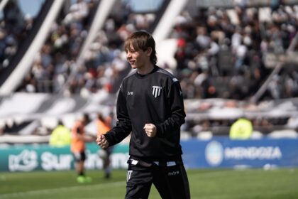 Joven futbolista celebra durante un partido frente a una tribuna llena