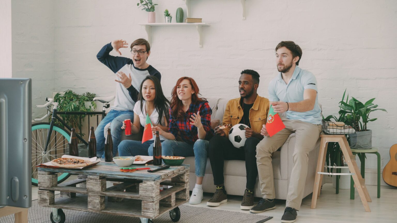 Hinchas mirando un partido de fútbol en vivo por televisión