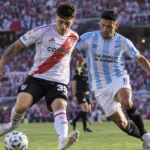 Un futbolista de river disputa la pelota con un jugador de atlético tucumán en un partido de la liga profesional