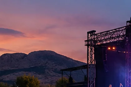 Escenario de un festival al aire libre con sierras bonaerenses al atardecer