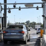 Vehículo circulando por una estación de peaje con cámaras y sensores