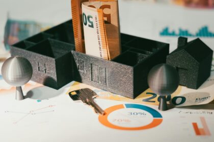 Llaves de vivienda junto a elementos de finanzas domésticas, fotografía ilustrativa de alquileres